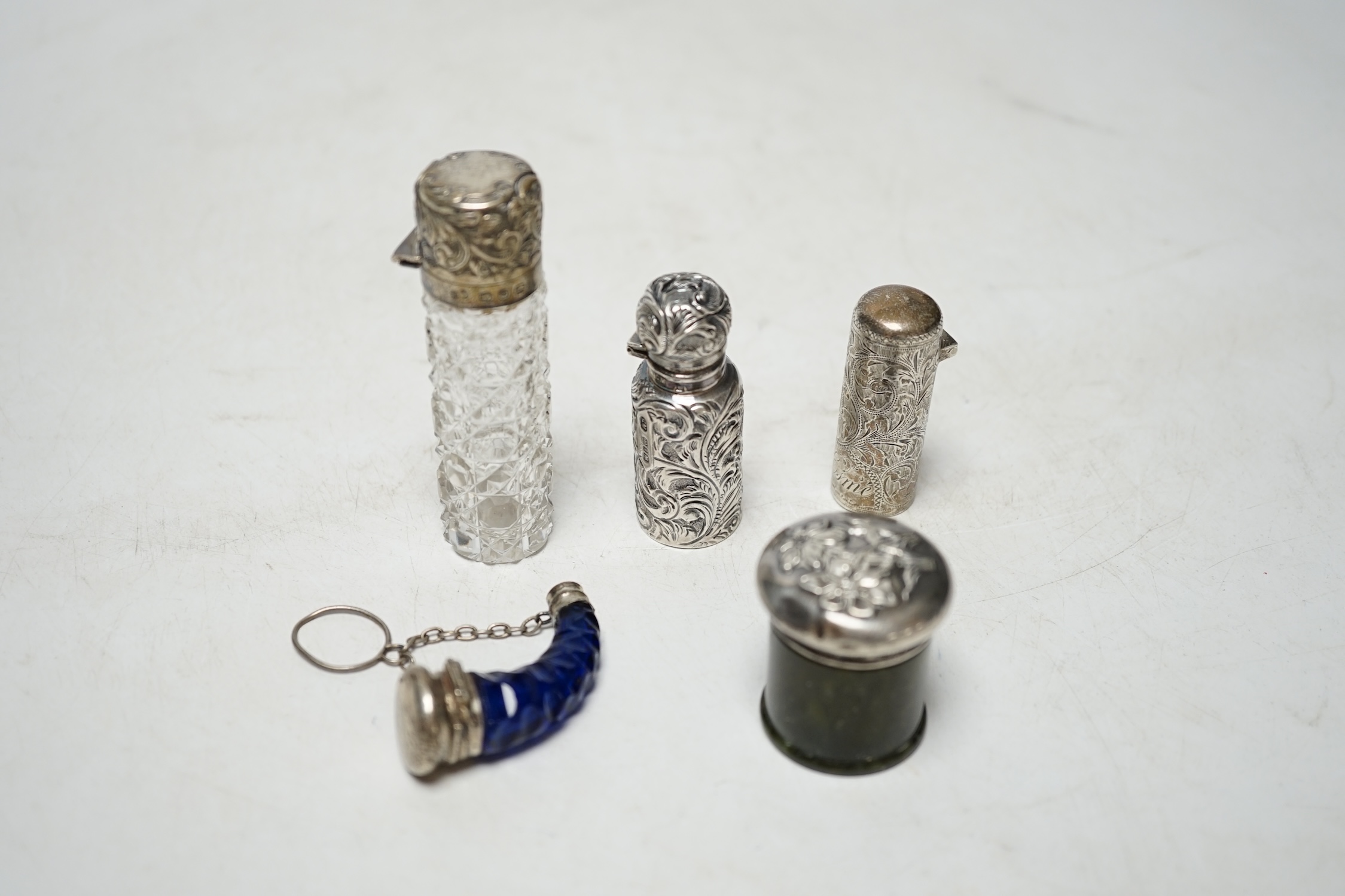 Four assorted late 19th/early 20th century silver or silver mounted scent bottles including engraved cylindrical by Hilliard & Thomasson, Birmingham, 1897, 47mm, together with a silver mounted hardstone toilet jar. Condi